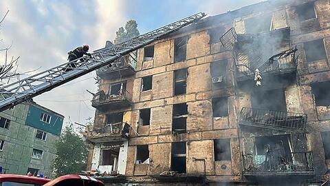 Feuerwehrleute löschen einen Brand, nachdem Raketen in ein mehrstöckiges Wohnhaus in Kryvyi Rih eingeschlagen sind.
