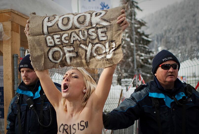 Nacktprotest in Davos: Ukrainerinnen demonstrieren barbusig am Zaun vor dem Weltwirtschaftsforum. Die Polizei greift ein - die Bilder.