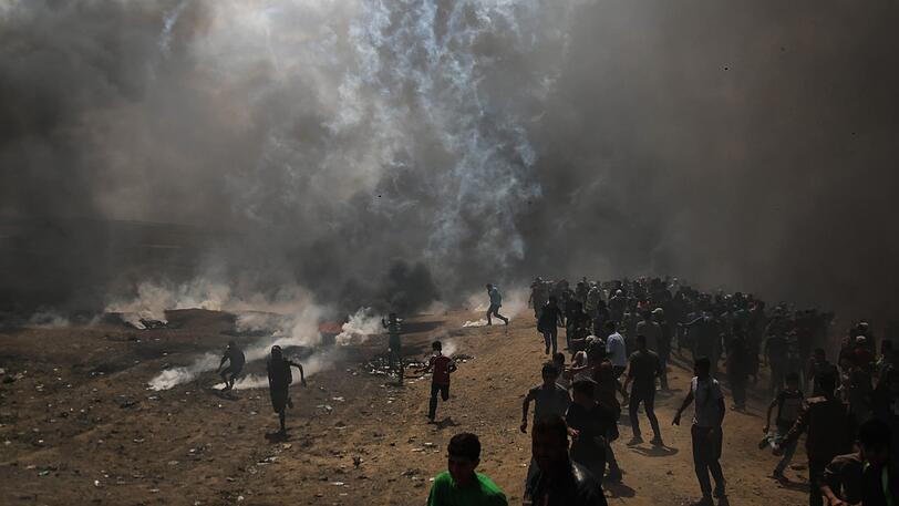Palästinenser flüchten vor dem Tränengas, abgefeuert von israelischen Sicherheitskräften, bei Protesten für die Rückkehr in ihre Heimat.