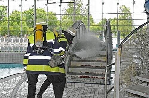 Ein Feuerwehrmann spritzt Chlorreste weg.