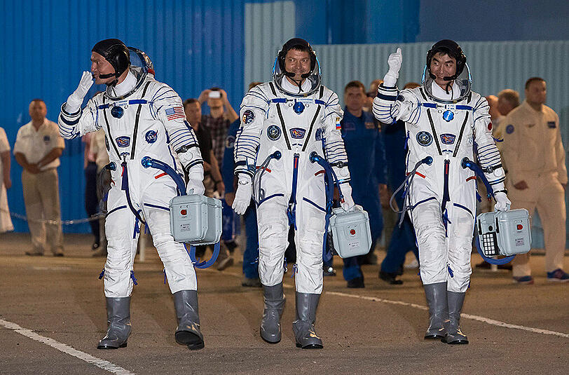 Die drei Raumfahrer (l-r) Kjell Lindgren (USA), Oleg Kononenko (Russland) und Kimiya Yui (Japan) präsentieren sich vor dem Start zur Internationalen Raumstation (ISS) in Baikonur, Kasachstan. Diese drei Raumfahrer kamen am Donnerstag auf der Raumstation ISS an.