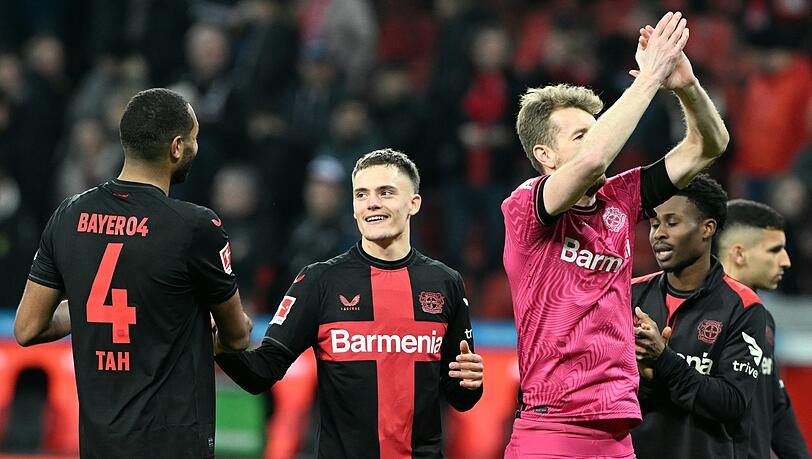 Leverkusens Jonathan Tah (l-r), Florian Wirtz, Torwart Lukas Hradecky, Amine Adli und Exequiel Palacios feiern den 2:0-Sieg.