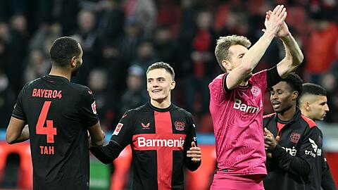 Leverkusens Jonathan Tah (l-r), Florian Wirtz, Torwart Lukas Hradecky, Amine Adli und Exequiel Palacios feiern den 2:0-Sieg.