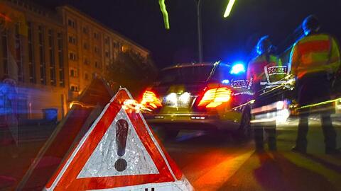 Ein Warndreieck mit dem Schriftzug "Unfall" steht vor einem Polizeifahrzeug. Foto: Patrick Seeger/dpa/Illustration