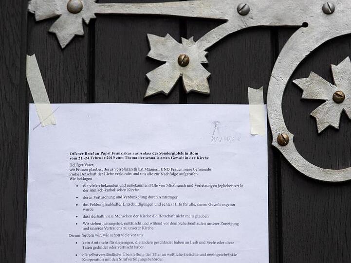 Ein Offener Brief an Papst Franziskus hängt an der Tür der katholischen Kirche "Heilig Kreuz" in Münster.