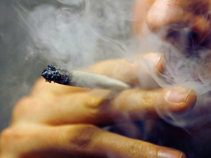 Ein Mann raucht einen Joint mit Marihuana. Foto: Daniel Karmann/dpa/Archivbild