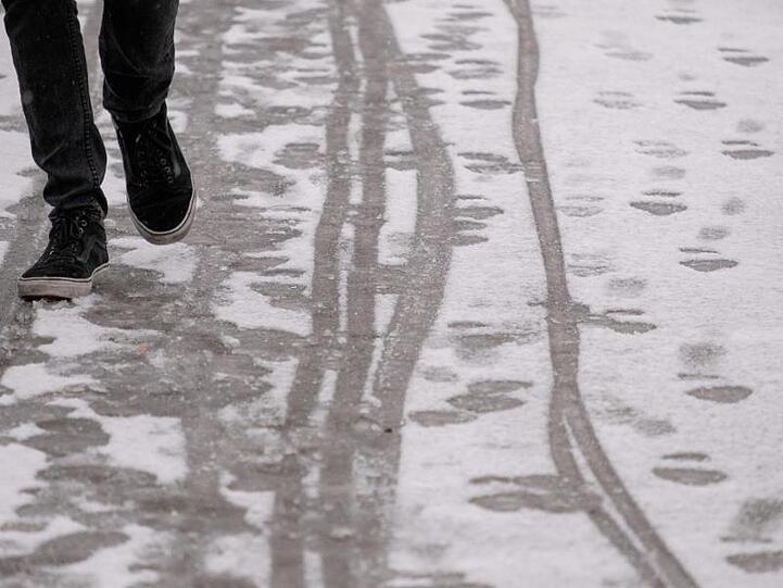 Ein Passant hinterlässt Spuren im Schnee. Foto: Marijan Murat/Archiv