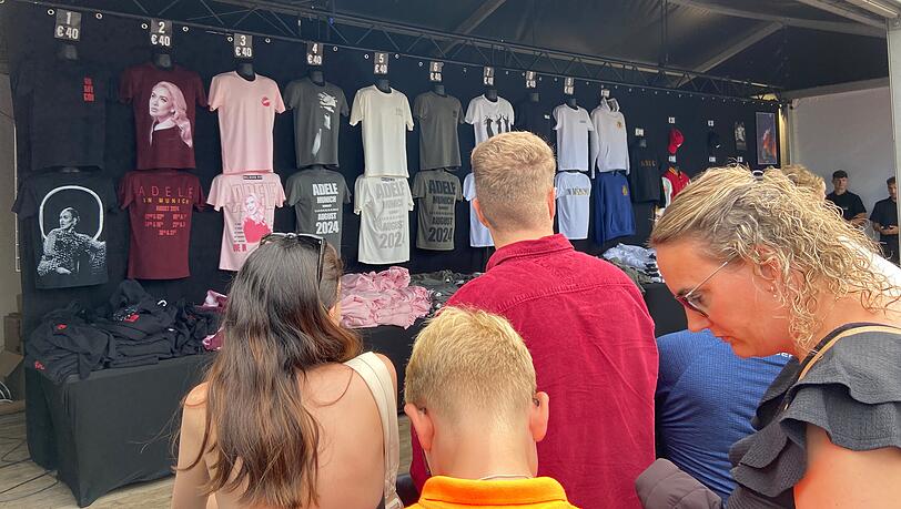 Wer ein Adele-T-Shirt haben möchte, muss an den zahlreichen Merch-Ständen 40 Euro hinblättert, daneben gibt es aber auch Caps, Tassen, Taschen, Hoodies und College-Jacken.