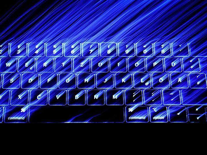 Die beleuchtete Tastatur eines Macbooks. Laut Merkel soll ein Online-Zugangsgesetz jedem Bürger eine digitale Identität geben.