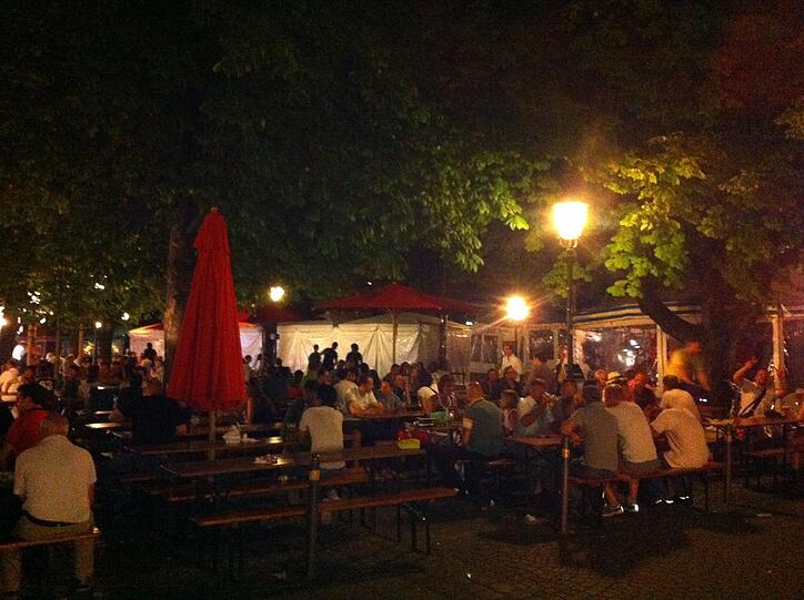 Abends im Biergarten gehen am Viktualienmarkt die Lichter an.
