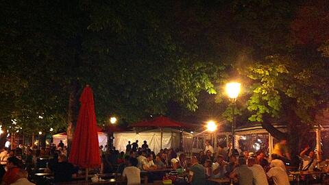 Abends im Biergarten gehen am Viktualienmarkt die Lichter an.