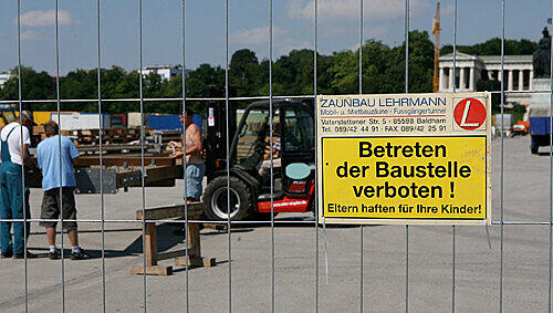 Mehrere Bauarbeiter arbeiten am Mittwoch (16.07.2008) hinter einem Absperrzaun auf der Theresienwiese. Mehrere Bauarbeiter arbeiten am Mittwoch (16.07.2008) hinter einem Absperrzaun auf der Theresienwiese.