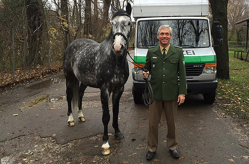 Der Leiter der Reiterstaffel liefert Schimmelwallach Hugo bei seinem neuen Besitzer ab.