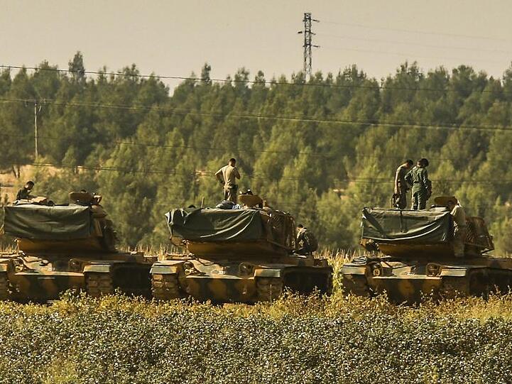 Türkische Soldaten stehen nahe der syrischen Grenze auf Panzern.