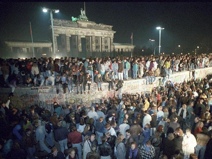 Menschen feiern auf der Berliner Mauer in der Nacht vom 9. auf den 10. November 1989.
