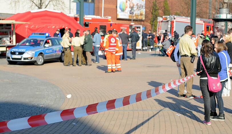 Jugendliche stehen vor einem Absperrband am Einkaufszentrum in Oberhausen.