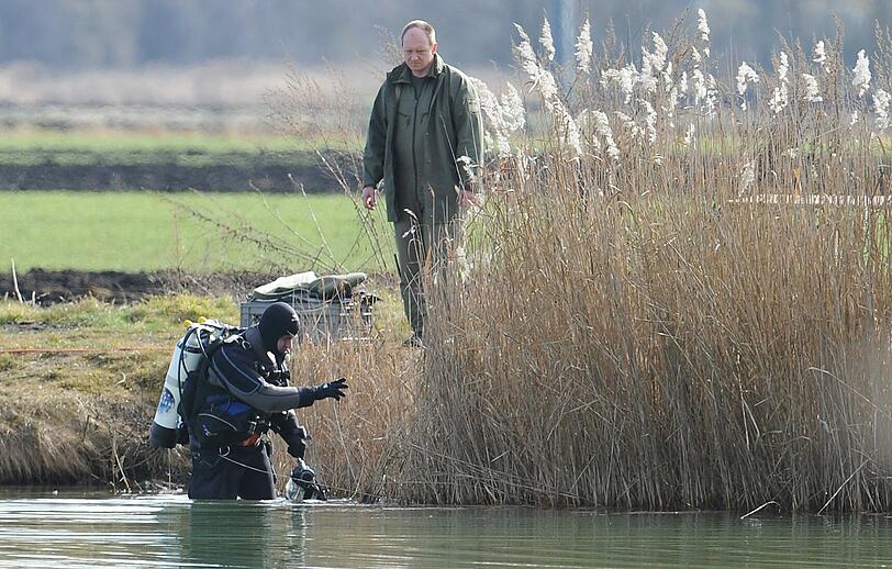 Ein Taucher steigt am Montag in den Rathei-Weiher. Hier wurde am Sonntag die Leiche eines Mädchens gefunden.