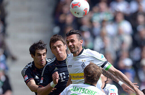 Der Gladbacher Martin Stranzl (r) und die Münchener Javi Martinez (l) und Mario Mandzukic versuchen den Ball zu spielen.