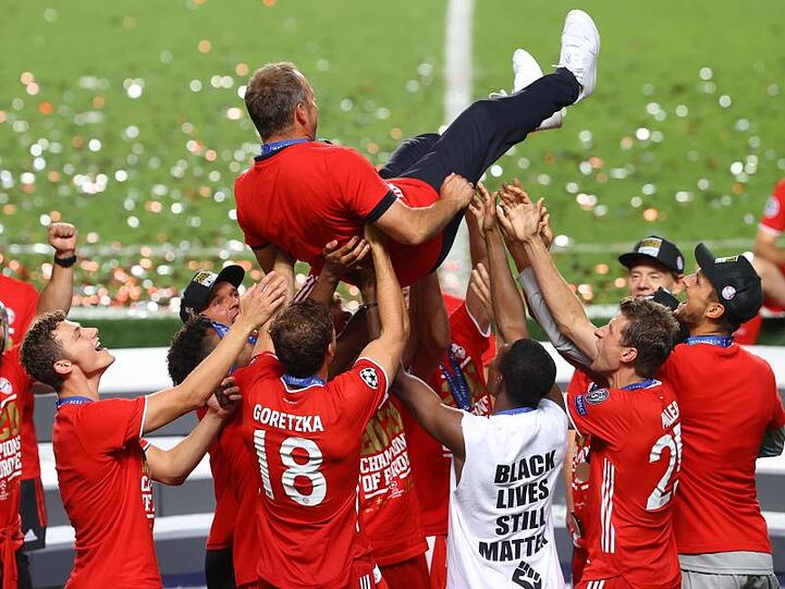 Die Spieler werfen Cheftrainer Hansi Flick in die Luft. Foto: Julian Finney/Getty Images via UEFA/dpa