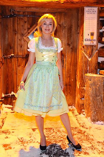 Die Schauspielerin Saskia Valencia im pastell-gelben Dirndl.