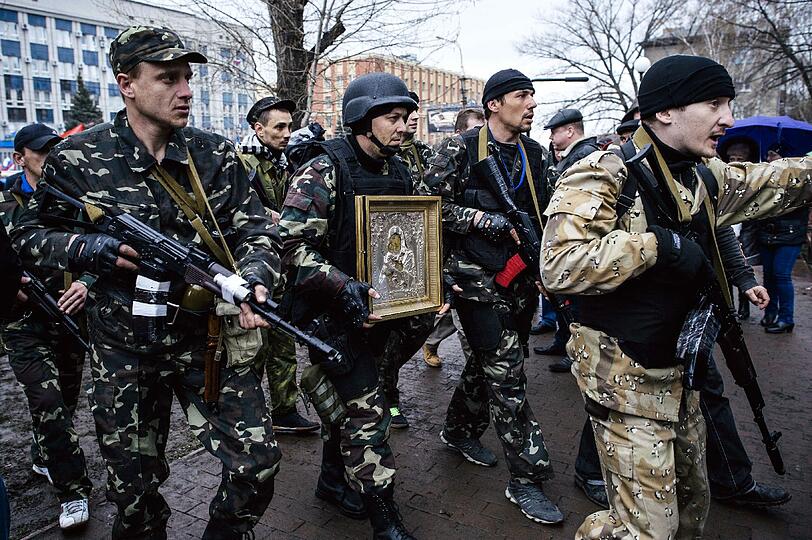 In der ukrainischen Stadt Lugansk tragen bewaffnete Seperatisten eine Ikone der Maria Magdalena vor sich her.