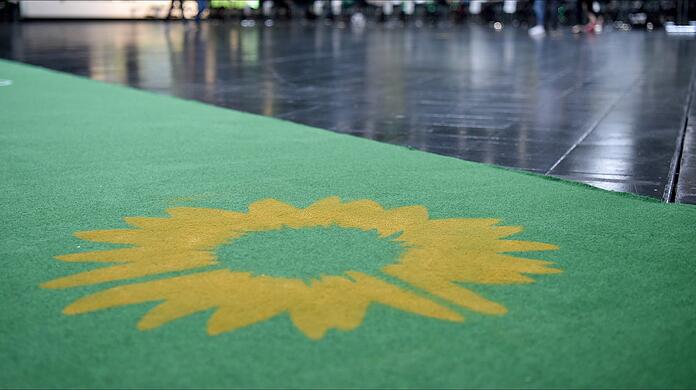 Das Logo der Partei, eine Sonnenblume, ist auf einem grünen Teppich zu sehen