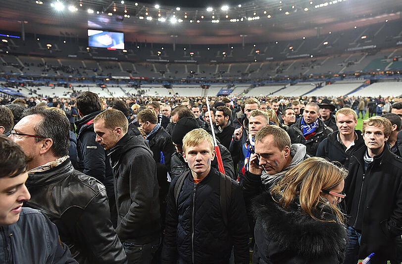 Menschen stehen nach dem Spiel auf dem Rasen des Stade de France. Teilweise war das Mobilfunknetz unterbrochen.