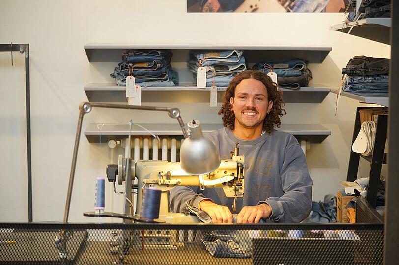 Manuel Egner an der Industrienähmaschine im Nudie Jeans Repair Shop an der Rumfordstraße 2 in München. Hier repariert er Jeans für die Kundinnen und Kunden kostenlos. Manuel Egner an der Industrienähmaschine im Nudie Jeans Repair Shop an der Rumfordstraße 2 in München. Hier repariert er Jeans für die Kundinnen und Kunden kostenlos.