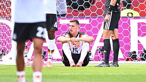 Nico Schlotterbeck sitzt im Spiel gegen die Elfenbeink&uuml;ste verletzt am Boden.