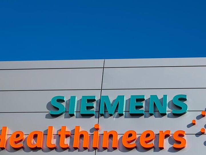 Logos und Schriftzug am Hauptquartier des Medizintechnikkonzerns Siemens Healthineers. Foto: Daniel Karmann/dpa/Archivbild