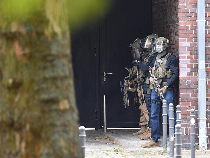Bewaffnete Einsatzkräfte der Polizei vor dem Schulgebäude.