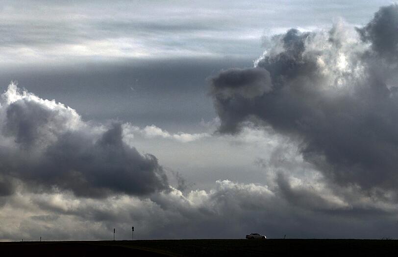 Dichte Wolken ziehen sich am 30.03.2015 über einer Straße bei Marktheidenfeld ( Bayern) zusammen.