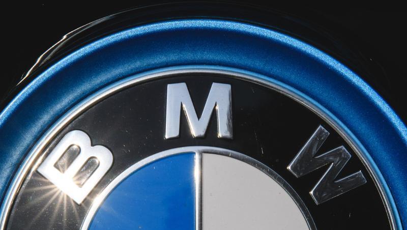 Die Sonne spiegelt sich in einem Logo des Autoherstellers BMW. Foto: Sebastian Gollnow/dpa/Archivbild