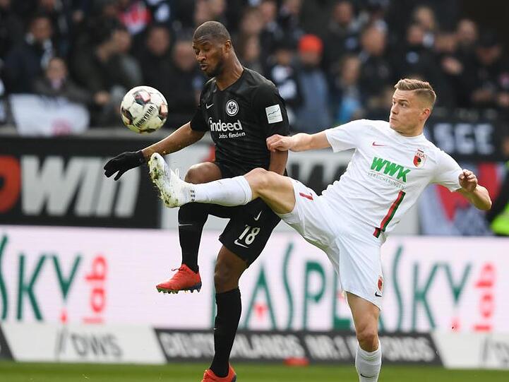 Frankfurts Almamy Toure (l) und Augsburgs Alfred Finnbogason kämpfen um den Ball. Foto: Arne Dedert