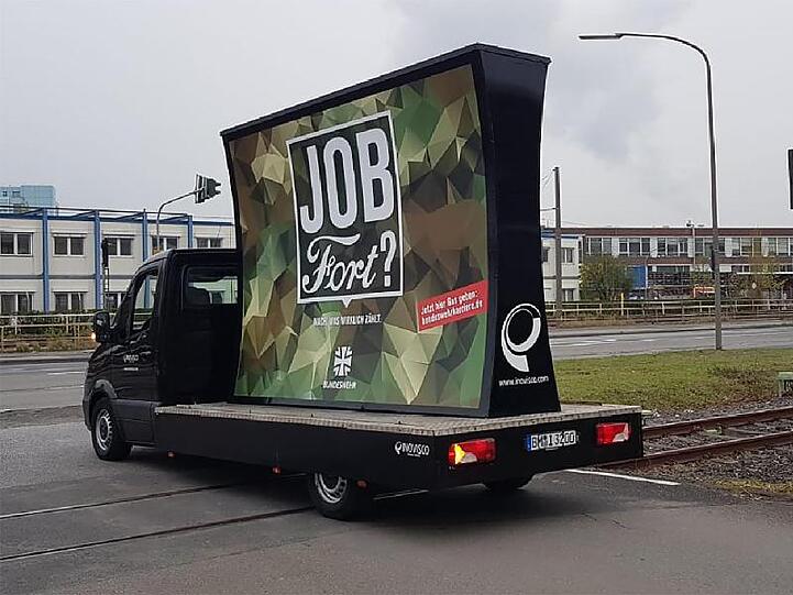 Ein Lieferwagen mit der Bundeswehr-Anzeige fährt am Ford-Werk in Köln vorbei.