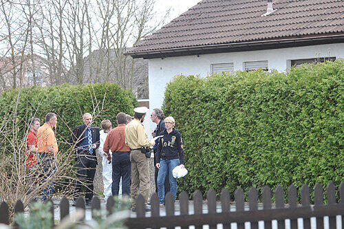Die Ermittler vor dem Tatort: In dem beschaulichen Einfamilienhaus hinter der Hecke geschah die Bluttat.