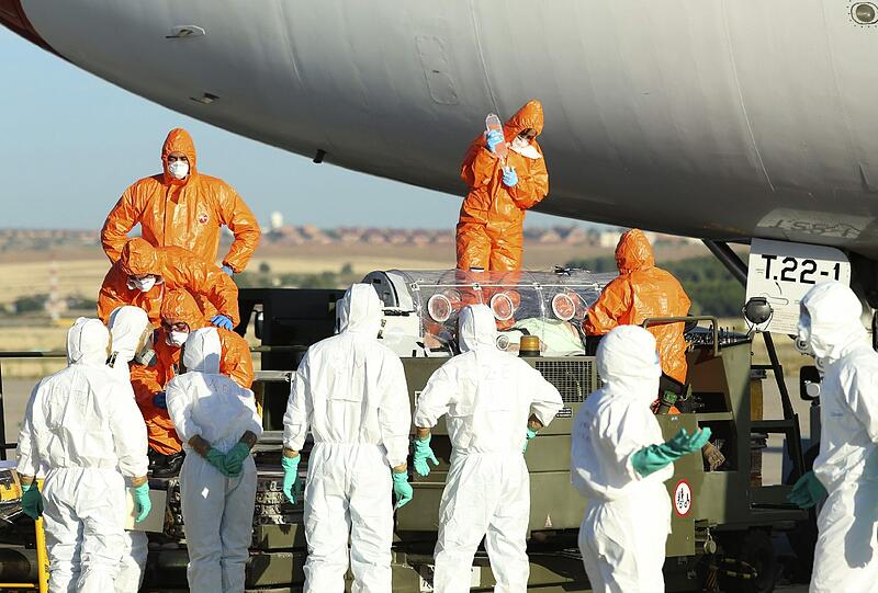 Es herrscht höchste Sicherheitsstufe. Mit Gasmasken und luftdichten Anzügen gehen die Helfer vor.