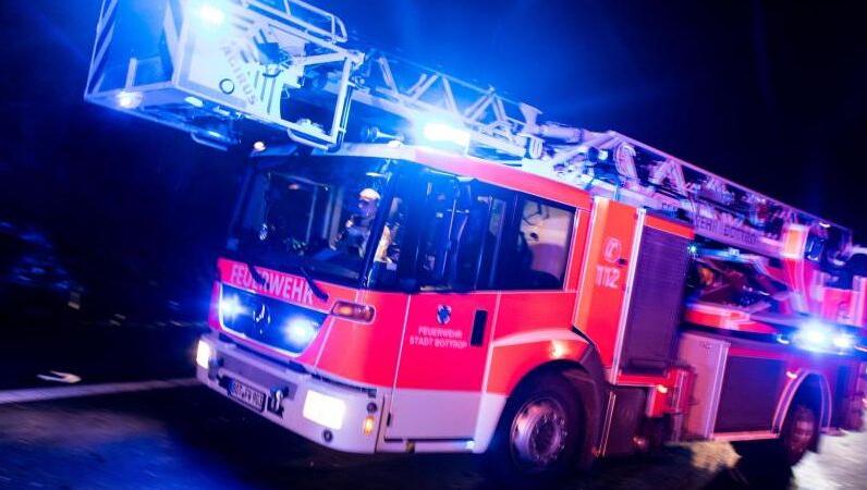 Ein Drehleiterwagen der Feuerwehr fährt mit Blaulicht an einer Unfallstelle vorbei. Foto: Marcel Kusch/dpa Ein Drehleiterwagen der Feuerwehr fährt mit Blaulicht an einer Unfallstelle vorbei. Foto: Marcel Kusch/dpa