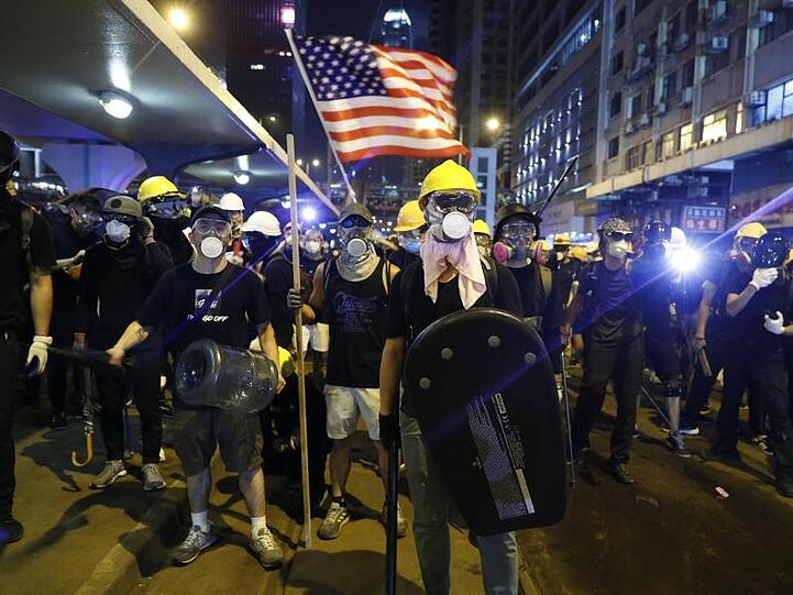Demonstranten schwenken eine US-Flagge und bereiten sich auf die Konfrontation mit der Polizei vor.