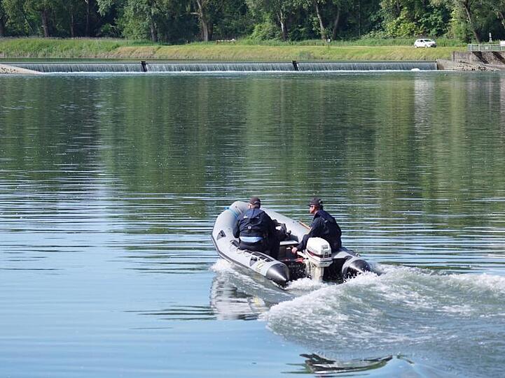 Einsatzkräfte fahren nach dem Schlauchbootunglück den Rhein ab.