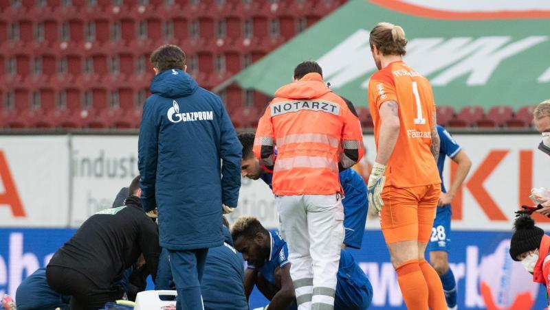 Ein Notarzt kümmert sich um Mark Uth. Die Verletzung des Schalke-Stürmers hat die Partie in Augsburg überschattet.