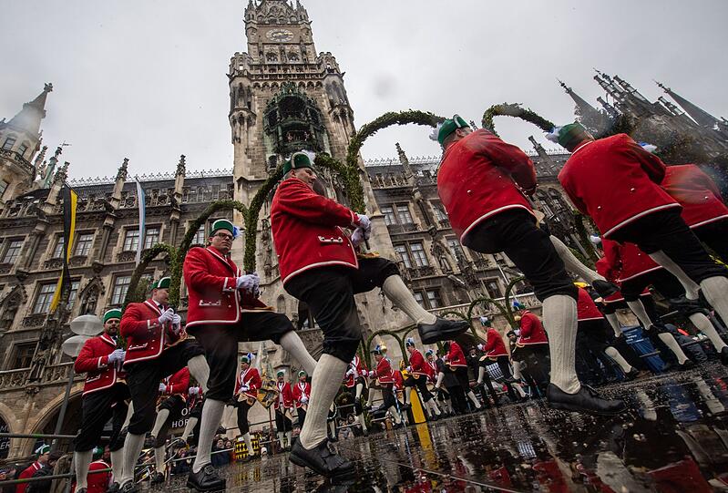 Schäffler tanzen vor dem Neue Rathaus am Marienplatz. Während der Pest im Jahr 1517 entstand in München der Schäfflertanz, durch den die Menschen nach der schweren Zeit aufgeheitert und aus ihren Häusern hervorgelockt werden sollten.