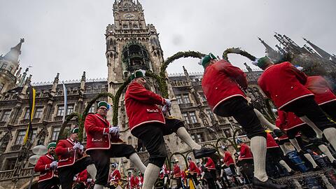 Schäffler tanzen vor dem Neue Rathaus am Marienplatz. Während der Pest im Jahr 1517 entstand in München der Schäfflertanz, durch den die Menschen nach der schweren Zeit aufgeheitert und aus ihren Häusern hervorgelockt werden sollten.