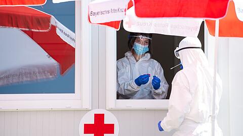 Mitarbeiter vom Bayerischen Roten Kreuz stehen in einem Corona-Testzentrum an der A8 an der Rastanlage Hochfelln-Nord.