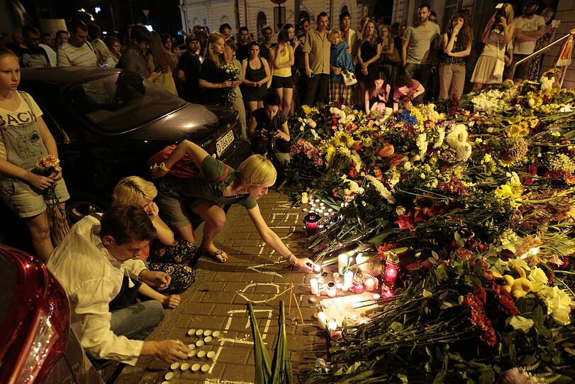 Vor der niederländischen Botschaft in Kiew legen Menschen Blumen nieder und gedenken der Opfer.