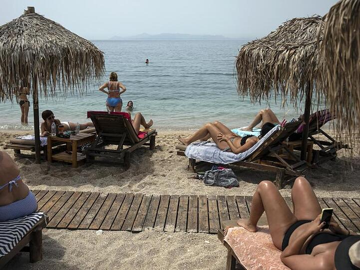 Urlauber liegen am Strand von Alimos (Griechenland).