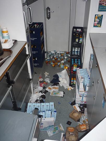 Chaos in der Zug-Küche: Getränkeflaschen, Milchtüten, Lebensmittel und Kaffee-Zubehör liegen kreuz und quer auf dem Boden.