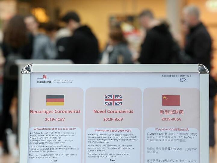 Am Hamburger Flughafen klärt ein Aufsteller über Verhaltensweisen in Bezug auf das Coronavirus hingewiesen. Viele Fluggesellschaften streichen ihre Flüge - vor allem nach Italien.