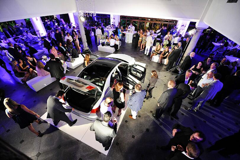 Die Besucher der Welcome-Party in der Villa Riso begutachten ein Modell der neuen Mercedes E-Klasse.