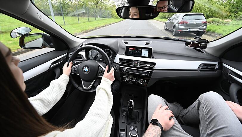 Eine Fahrschülerin sitzt am Steuer, daneben ihr Fahrlehrer. Eine Fahrschülerin sitzt am Steuer, daneben ihr Fahrlehrer.
